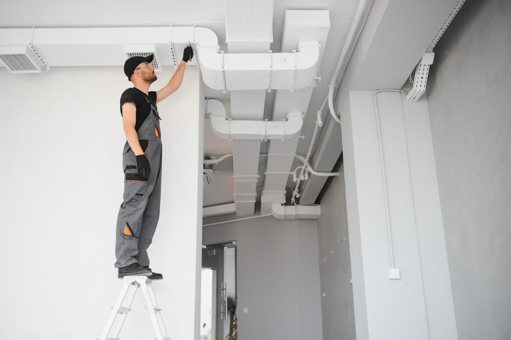 hvac services worker install ducted pipe system for ventilation and air conditioning in house photo