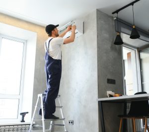 specialist cleans and repairs the wall air conditioner photo